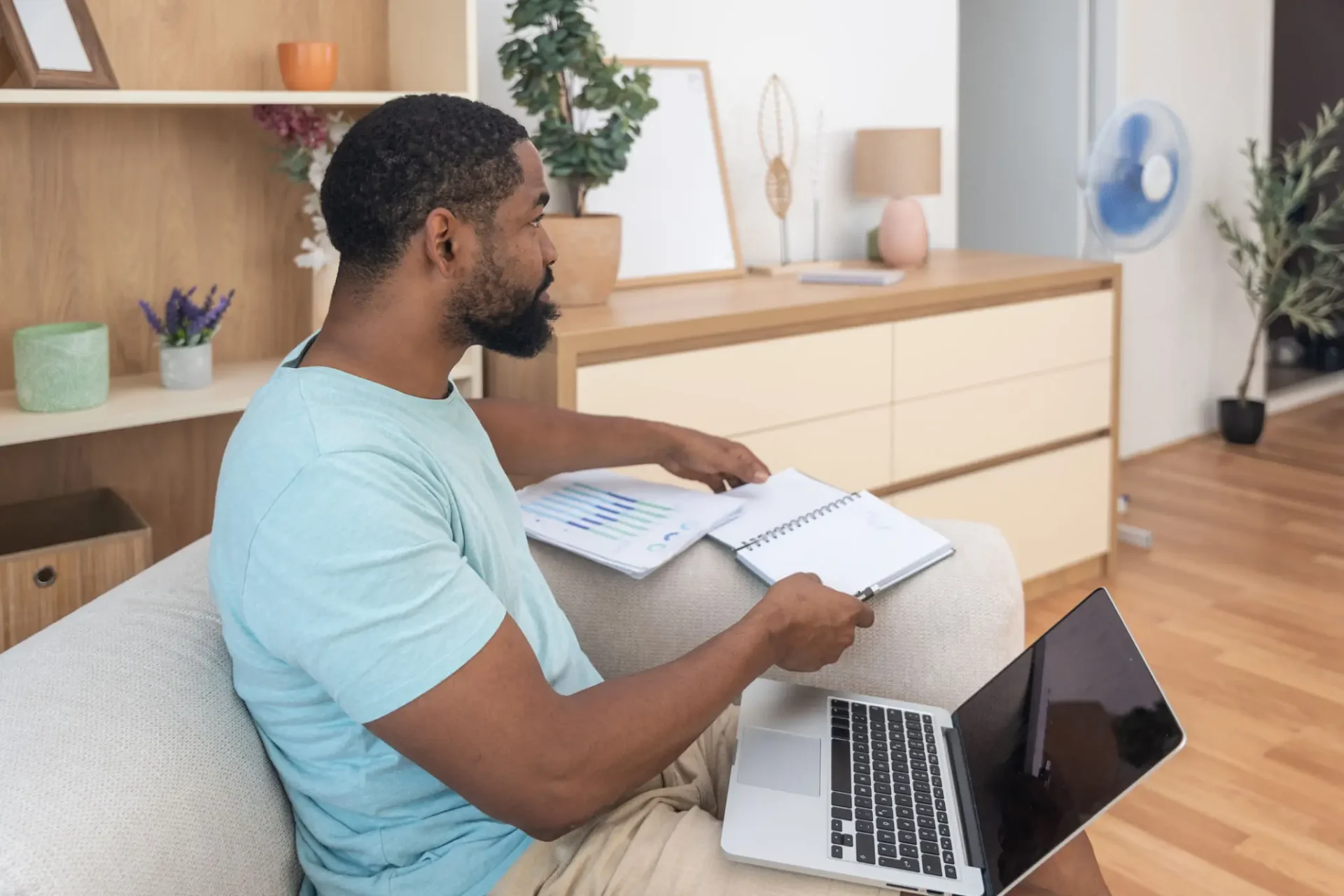 A man studying with books and a laptop at home.